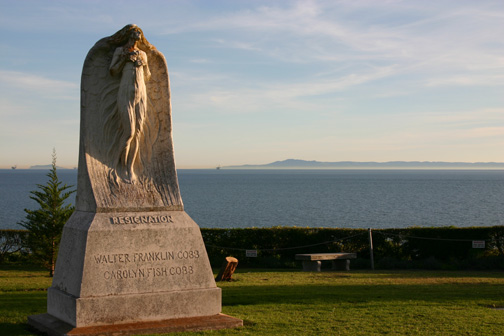 Photo of a headstone with the Pacific Ocean in the background.