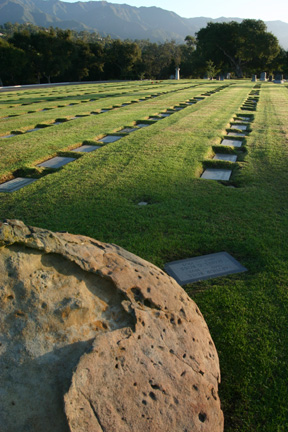 Photo of the Santa Barbara Cemetery's grounds with a boulder in the foreground.